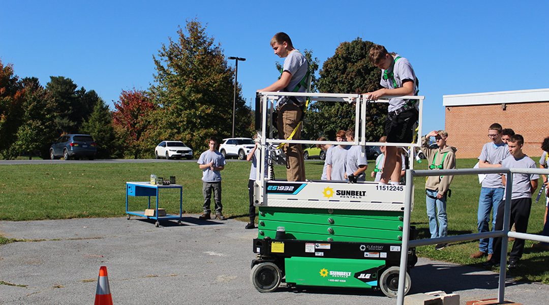 Electrical students working with a scissor lift.