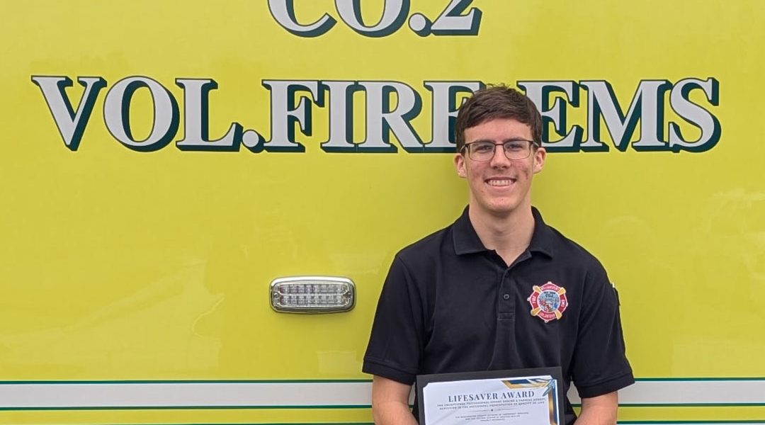 Tyler Staley posing with award